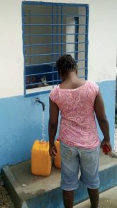 women filling a jug with water