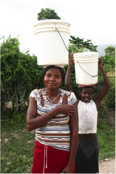 Woman and child carrying water buckets on their heads
